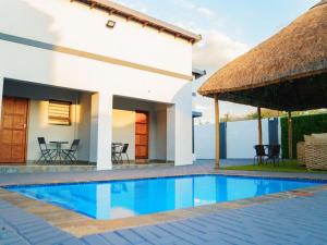 eine Villa mit Swimmingpool vor einem Haus in der Unterkunft Gee Heights Private Boutique Guest House in Thabazimbi
