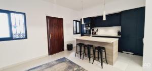 a kitchen with black and white walls and a counter with stools at Casa Suspiro in Estepona +39 photos