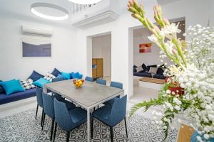 a living room with a table and blue chairs at Casa Suspiro in Estepona