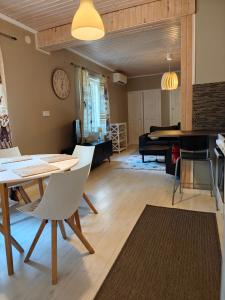 a living room with a table and chairs and a piano at Majoitus Eura in Kauttua