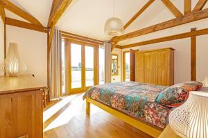a bedroom with a bed and a desk and windows at Amber Lodge in Ashover