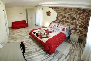 a bedroom with a red bed and a red couch at Le querce di mamre in Passaggio Di Assisi