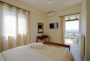 a bedroom with a bed and a view of the ocean at SEMIRAMIS SUITES with pool in Kalamata +172 photos