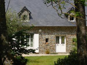 a brick house with a white door at MAISON d HOTES in May-sur-Orne