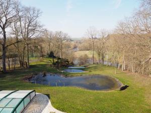 a view of a pond in a park with trees at MAISON d HOTES in May-sur-Orne