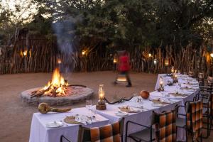 a group of tables with a fire pit in the background at Karongwe - River Safari Lodge in Hoedspruit +114 photos