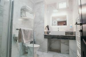 a bathroom with a toilet and a sink and a mirror at Hotel Restaurant Elite in Drobeta-Turnu Severin +45 photos