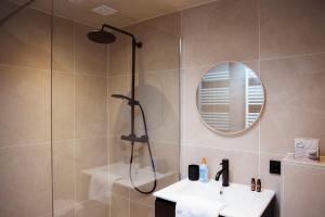 a bathroom with a shower and a sink and a mirror at Studio Strandkasteel, Free parking in Zandvoort