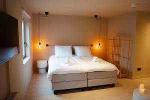 a bedroom with a large bed and a toilet at Studio Strandkasteel, Free parking in Zandvoort