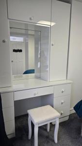 a white dressing table with a mirror and a stool at Double room in Reading in Earley