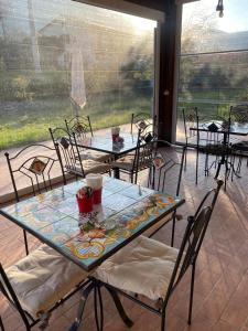 a patio with tables and chairs and a large window at Le querce di mamre in Passaggio Di Assisi