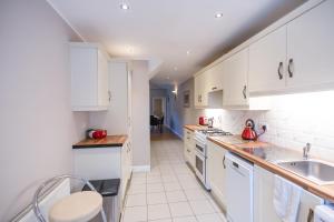 a kitchen with white cabinets and white appliances at Alensgrove Cottages #2 in Leixlip