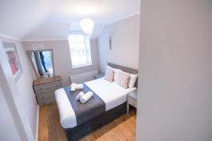 a small bedroom with a bed and a mirror at Alensgrove Cottages #2 in Leixlip
