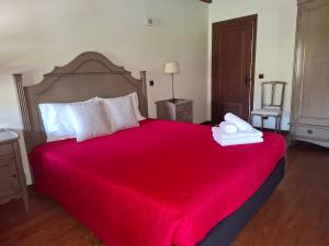 a bedroom with a large bed with a red blanket at Casa do Lello in Bragança