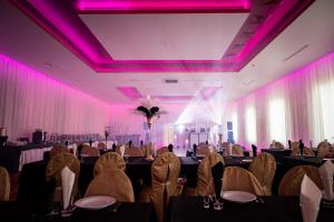 a banquet hall with tables and chairs and purple lights at Hotel Górecki in Lidzbark Warmiński +49 photos