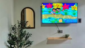 a flat screen tv hanging on a wall at Casa Elia l Beach Nook Suite l Walk to Beach&Surf in San Juan +24 photos