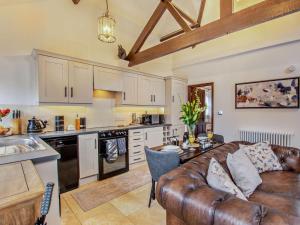 a living room with a leather couch and a kitchen at 1 Bed in Thirsk oc-94728 in Thirsk +9 photos