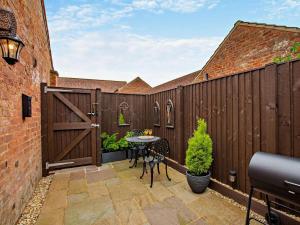 a patio with a wooden fence with a table and chairs at 1 Bed in Thirsk oc-94728 in Thirsk