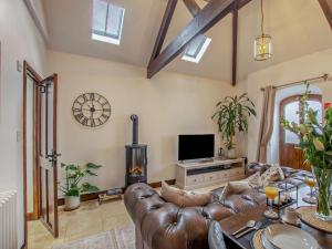 a living room with a leather couch and a fireplace at 1 Bed in Thirsk oc-94728 in Thirsk