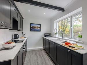 a kitchen with black cabinets and a large window at 2 Bed in Barnoldswick oc-83775 in Barnoldswick +5 photos