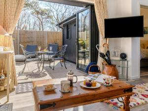 a living room with a table and chairs and a television at 1 Bed in Wareham oc-87150 in Stoborough +5 photos