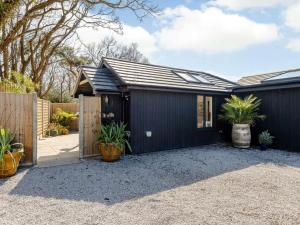 a black house with plants in a driveway at 1 Bed in Wareham oc-87150 in Stoborough