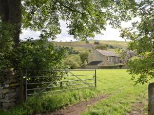 a fence in a field with a house in the background at 2 Bed in Leyburn oc-75441 in West Burton