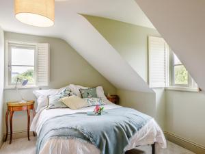 a bedroom with a bed and two windows at 3 Bed in Ilminster oc-77987 in Cudworth