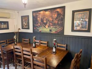 a dining room with a wooden table and a painting at Hillside Guesthouse Pushevo in Pushevo