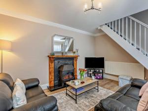 a living room with a fireplace and a staircase at 1 Bed in Alnwick oc-94380 in Embleton