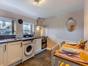 a kitchen with a table and a sink and a dishwasher at 1 Bed in Alnwick oc-94380 in Embleton +8 photos
