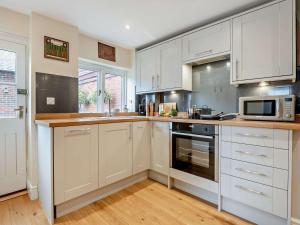 a kitchen with white cabinets and a microwave at 3 Bed in Stockbridge oc-94143 in Broughton