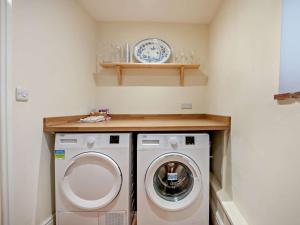 a laundry room with a washing machine and a plate on a shelf at 3 Bed in Stockbridge oc-94143 in Broughton