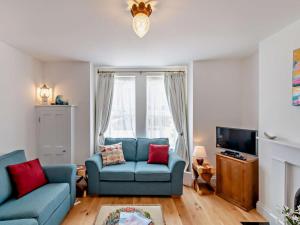 a living room with two blue couches and a tv at 2 Bed in Bembridge oc-94115 in Bembridge