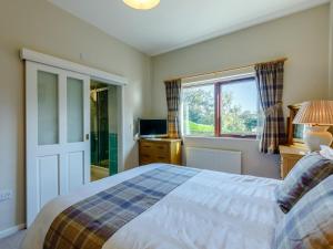 a bedroom with a bed and a window at 3 Bed in Wooler oc-93544 in Wooler