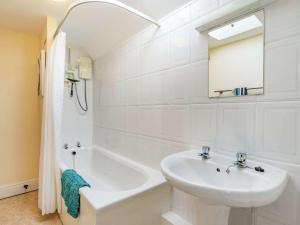 a white bathroom with a sink and a bath tub at 4 Bed in Consett oc-cn108 in Hunstanworth +20 photos