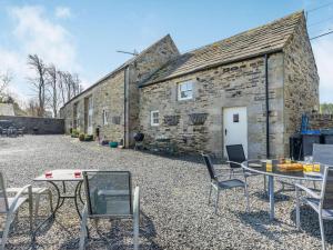 a table and chairs in front of a stone building at 4 Bed in Consett oc-cn108 in Hunstanworth