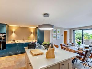a kitchen and dining room with blue cabinets and a table at 3 Bed in Leyburn oc-76395 in Askrigg