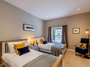 a bedroom with two beds and a chair at 3 Bed in Leyburn oc-76395 in Askrigg