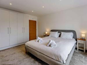 a bedroom with a large white bed with towels on it at 2 Bed in Sandown oc-83617 in Sandown