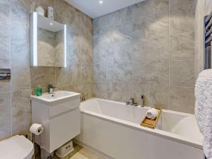 a bathroom with a tub and a toilet and a sink at 2 Bed in Sandown oc-83617 in Sandown +7 photos