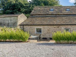 an old stone house with a bench in front of it at 4 Bed in Skipton oc-84017 in Rylstone