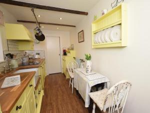 a kitchen with yellow cabinets and a table with chairs at 2 Bed in Otley oc-75268 in Lindley +10 photos