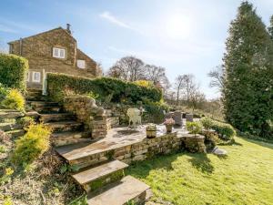 an old stone house with a stone staircase in a yard at 2 Bed in Otley oc-75268 in Lindley