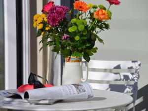 a vase with flowers and a book on a table at 2 Bed in Kewstoke oc-57144 in Weston-super-Mare