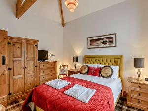 a bedroom with a large bed with a red blanket at 3 Bed in Beadnell oc-cn037 in Beadnell