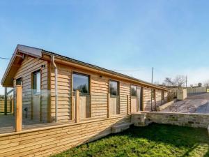 a wooden house with windows and a yard at 2 Bed in Leyburn oc-91102 in Finghall