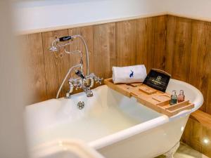 a bath tub with a faucet in a bathroom at 2 Bed in Leyburn oc-91102 in Finghall +33 photos