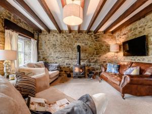 a living room with leather furniture and a stone wall at 2 Bed in Bishop Auckland oc-93111 in Westgate