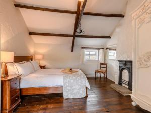 a bedroom with a bed with a table and a fireplace at 2 Bed in Bishop Auckland oc-93111 in Westgate